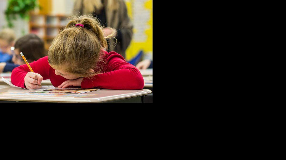 
Gifted student Kate Quinton, 9, writes on a sheet of paper at McCollom Elementary School. (Jan. 7, 2015)
