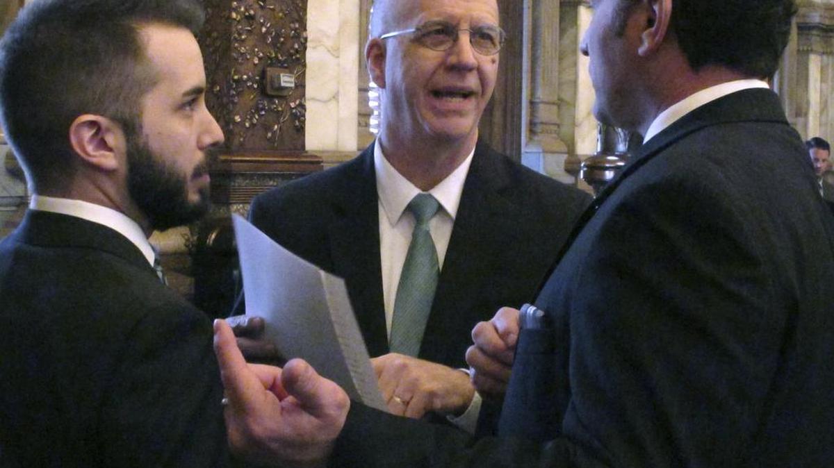 J.G. Scott, center, chief fiscal analyst for the Kansas Legislature’s research staff, confers with Zach Fridell, left, an attorney on lawmakers’ bill-drafting staff, and state Sen. Ty Masterson, R-Andover, during a Senate debate on budget legislation Wednesday.