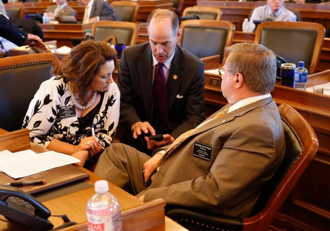 Rep. Erin Davis of Olathe; Rep. Steven Johnson, Assaria; and Rep. Mark Hutton, Wichita, meet after the Kansas House recessed Wednesday morning.