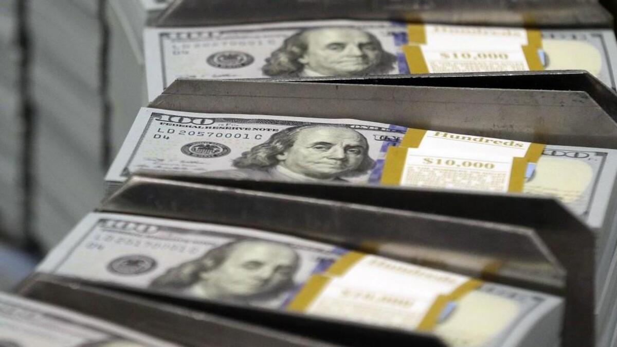 FILE - In this Sept. 24, 2013, file photo, just cut stacks of $100 bills make their way down the line at the Bureau of Engraving and Printing Western Currency Facility in Fort Worth, Texas. (AP Photo/LM Otero, File)