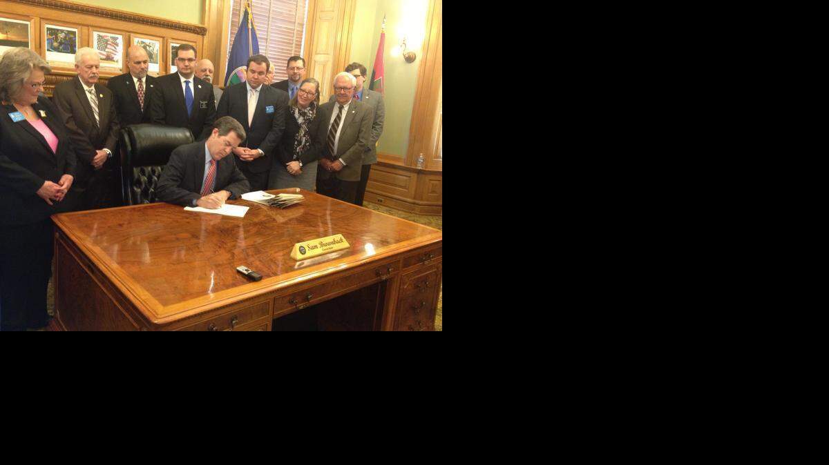 
Gov. Sam Brownback signs the bill joined by lawmakers and representatives of the National Rifle Association and Kansas State Rifle Association.

