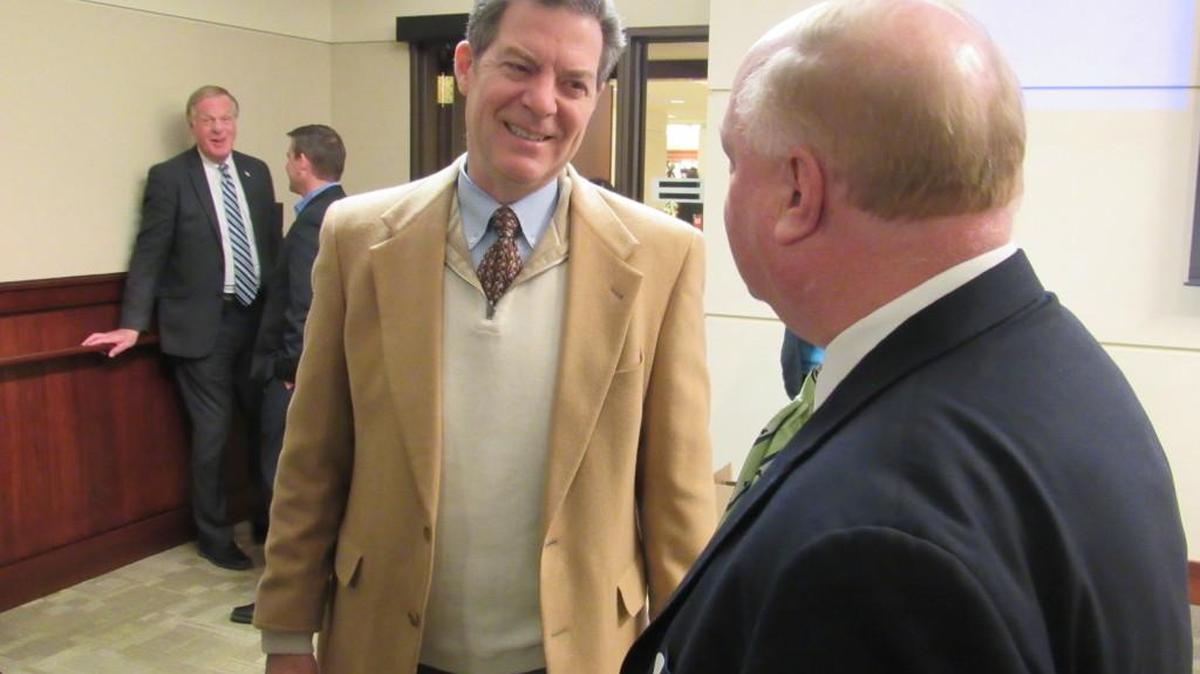 Gov. Sam Brownback, left, greets small-business owners Wednesday at the Capitol in Topeka.