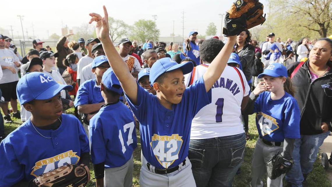 
Braeson Reese-Scott throws his hands in the air after his name was announced during the opening night for League 42, a youth baseball league. (April 27, 2014)
