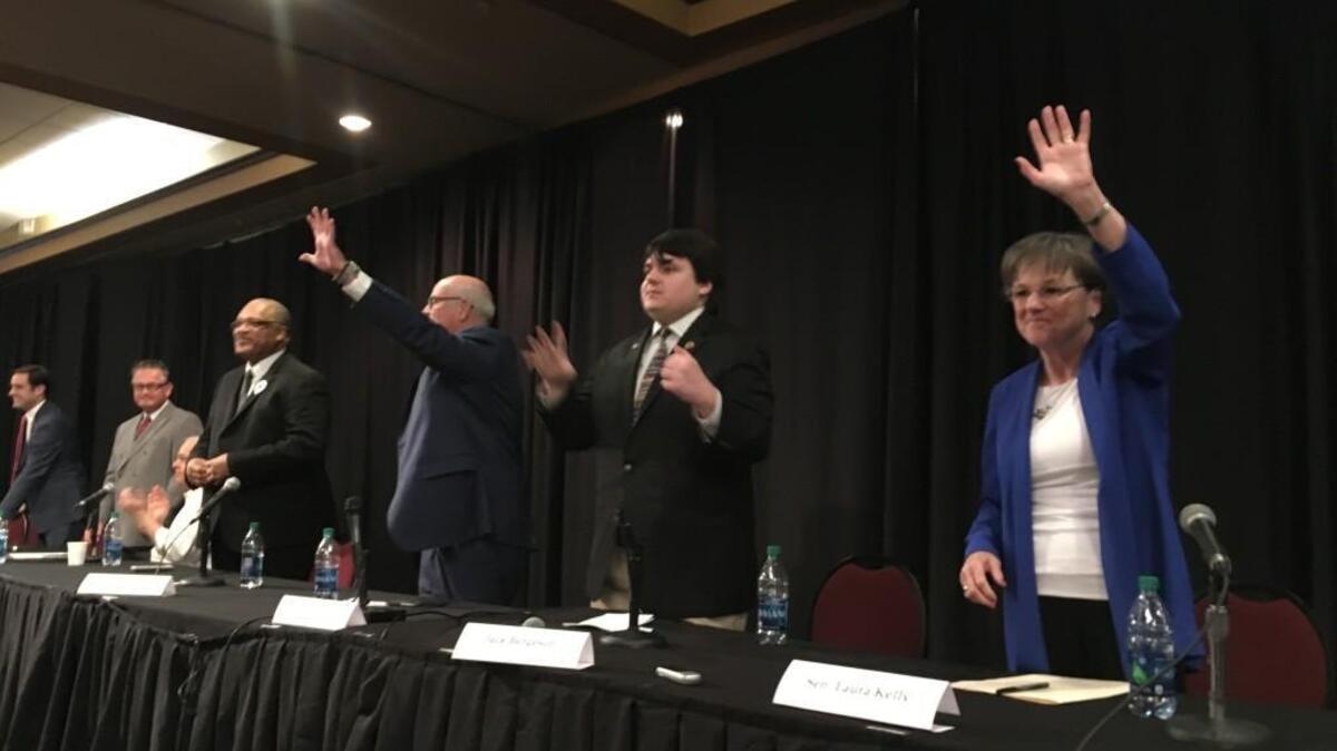Kansas Democratic candidates for governor wave at the end of a forum Saturday. The state party is experiencing its first contested primary for governor in decades.