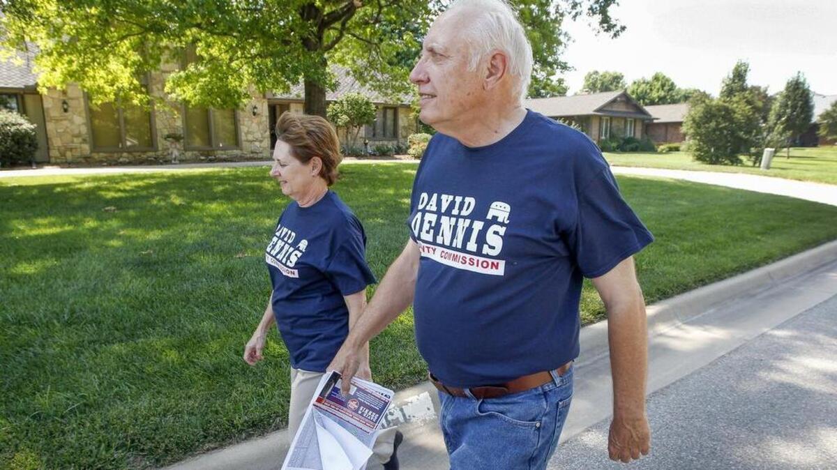 David Dennis, right, and his wife, Janet, campaign through his neighborhood in west Wichita in June.