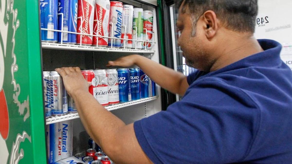Moe’s Mart employee Faizul Bary stocks up the cooler at the east-side minimart with 3.2 beer Tuesday. (March 16, 2016)