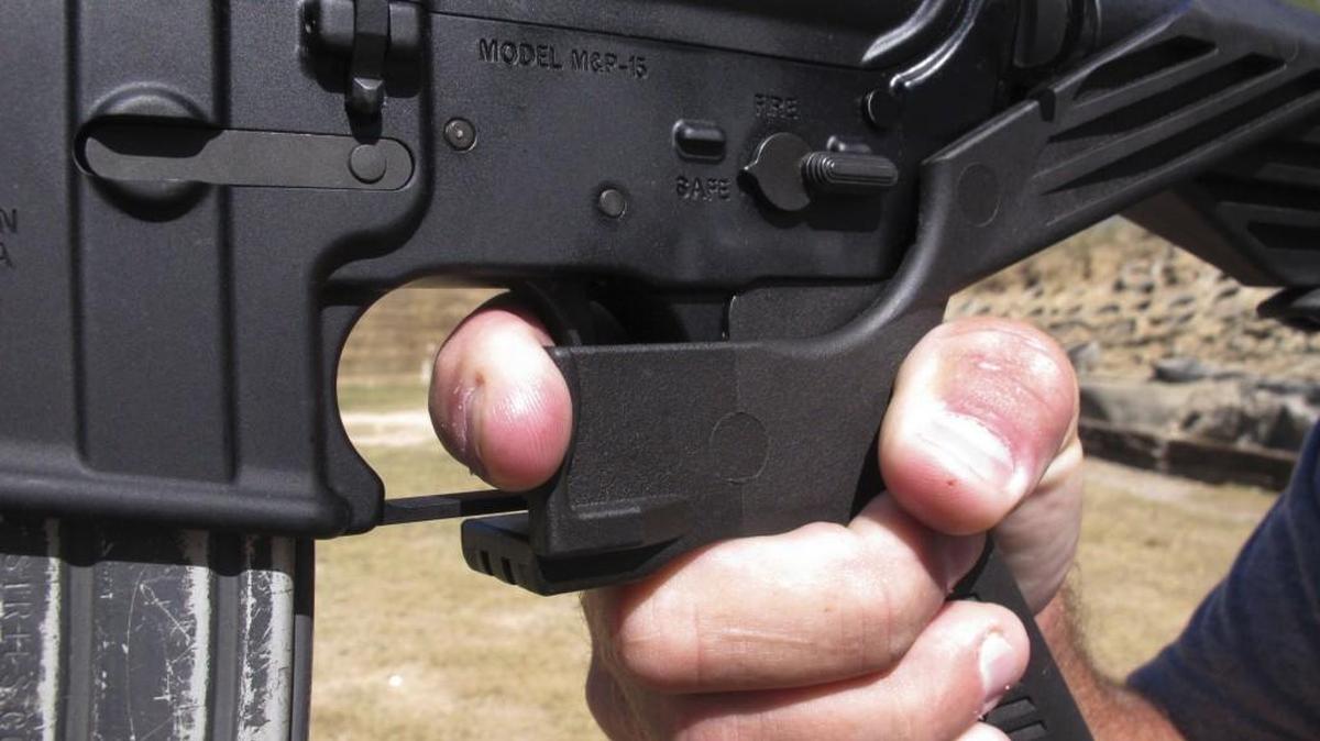 A shooting instructor demonstrates the grip on an AR-15 rifle fitted with a bump stock.
