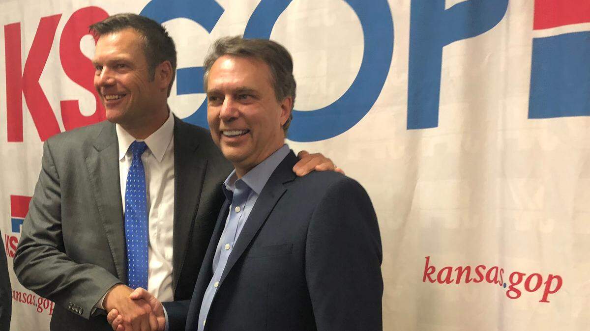 Kansas Secretary of State Kris Kobach (left) poses with Gov. Jeff Colyer, the man he narrowly beat in the Republican primary, during a unity event at Kansas Republican Party headquarters in Topeka on Thursday.