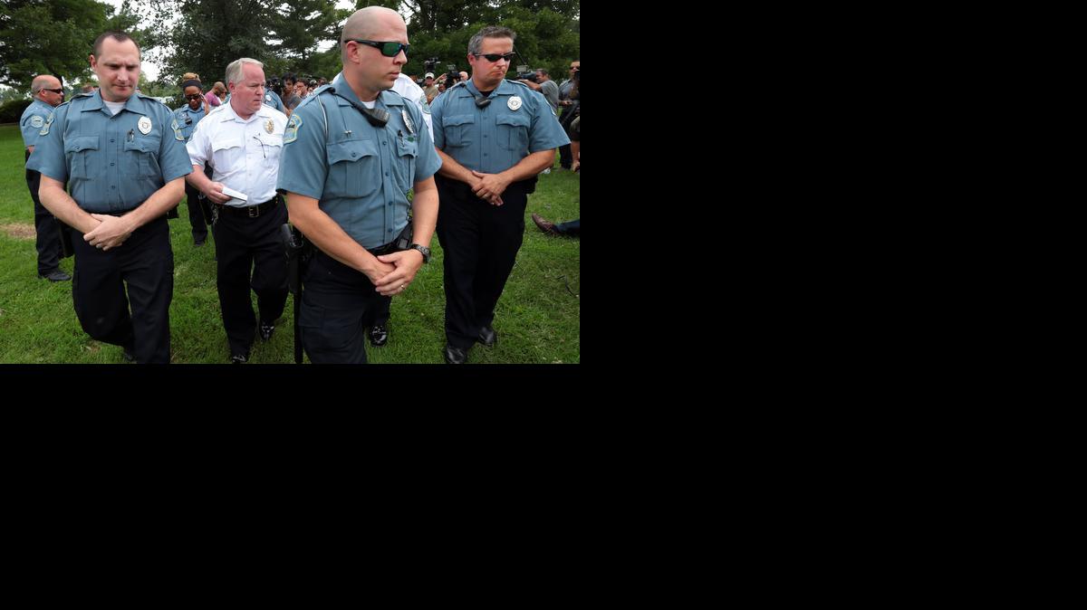 
Ferguson Police Chief Tom Jackson is surrounded by his officers as he leaves a news conference in Forestwood Park on Aug. 15. The Ferguson police department will be the focus of a federal investigation.

