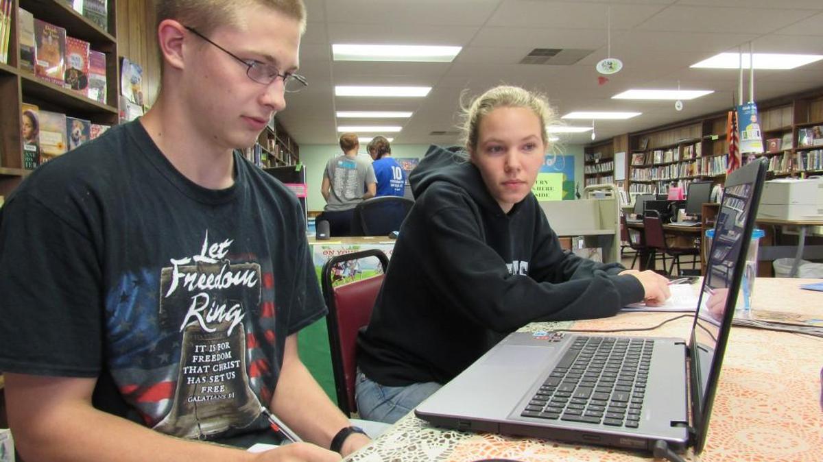 Emporia State University student Christianne Parks tutors Howard Brammell, 17, in math at the Allen library. She said she’ll probably move away after she finishes school if the town’s internet service doesn’t get better.