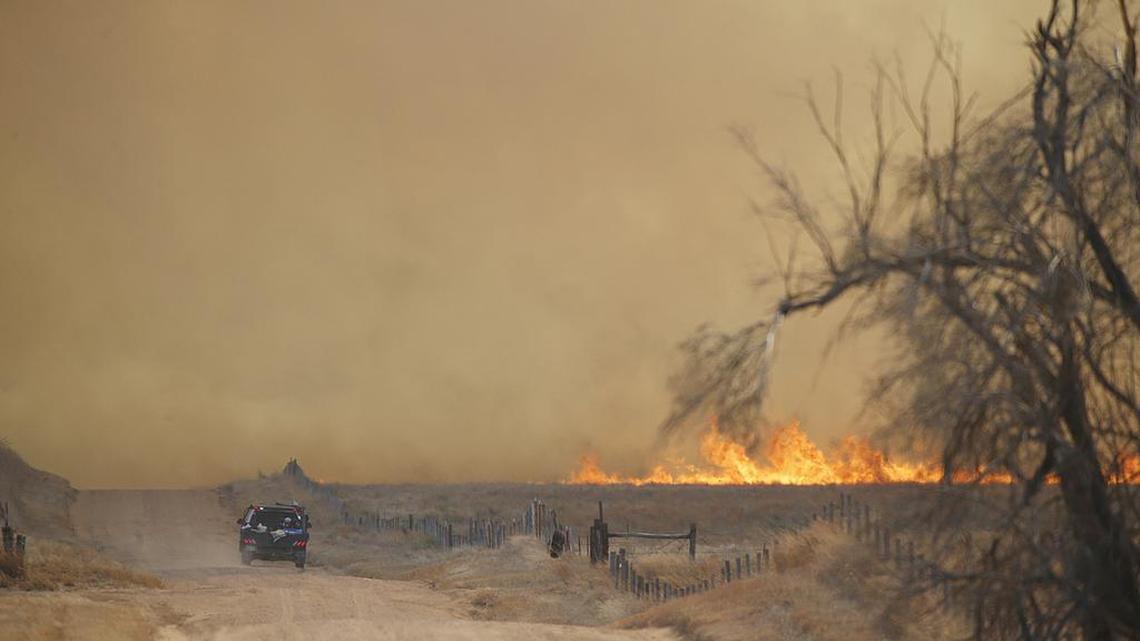 Fire jumps a road in Comanche County near the Kiowa county line on March 7.