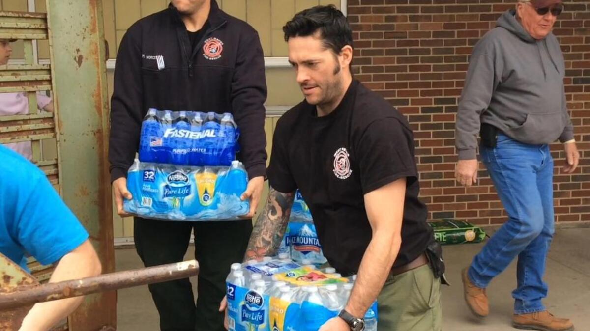 Members of West Metro Fire Rescue out of Lakewood, Colorado, help load water to be taken to the town of Englewood, which had its well dry up earlier last week.