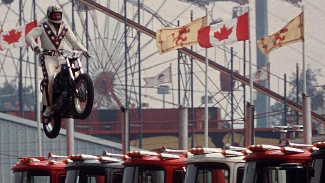 Daredevil motorcyclist Evel Knievel sails over seven Mack trucks during a practice jump in the open-air Canadian national exhibition stadium in Toronto on Aug. 20, 1974.