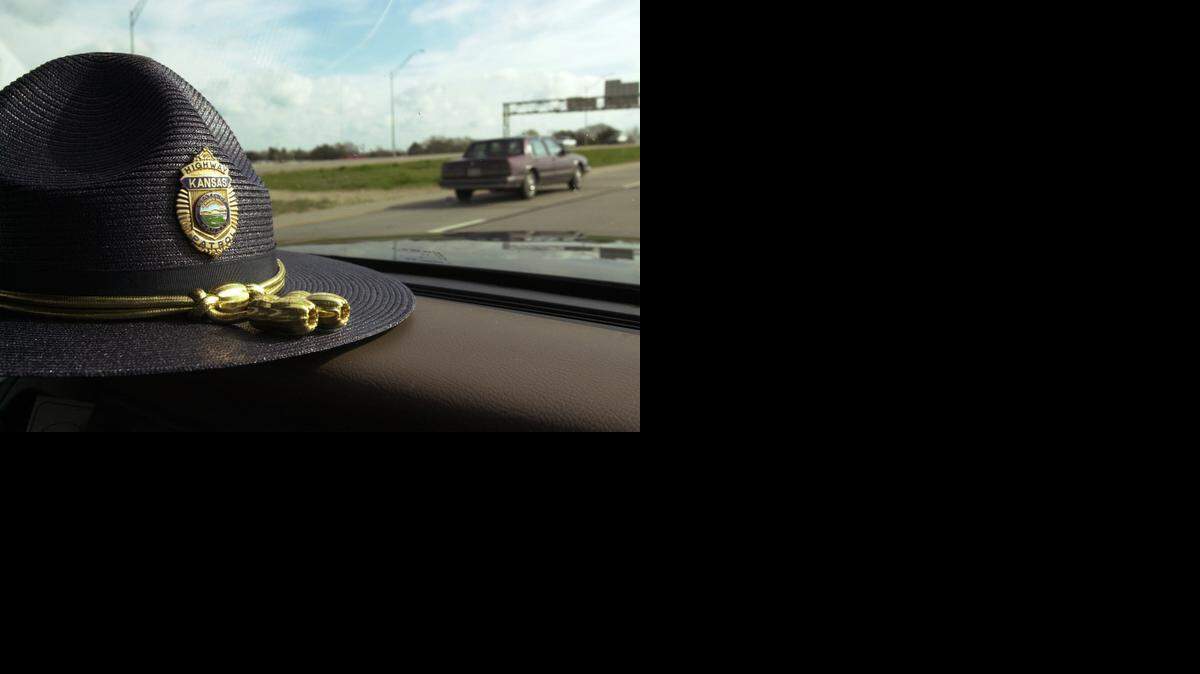 
A Kansas Highway Patrol trooper’s hat lays on his dashboard while he writes a ticket for a speeder he pulled over. 
