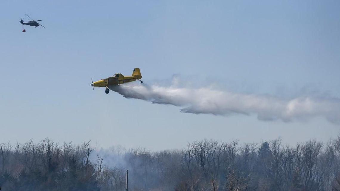 A crop duster drops water on a wildfire along Highway 61 just north of Hutchinson on March 7.