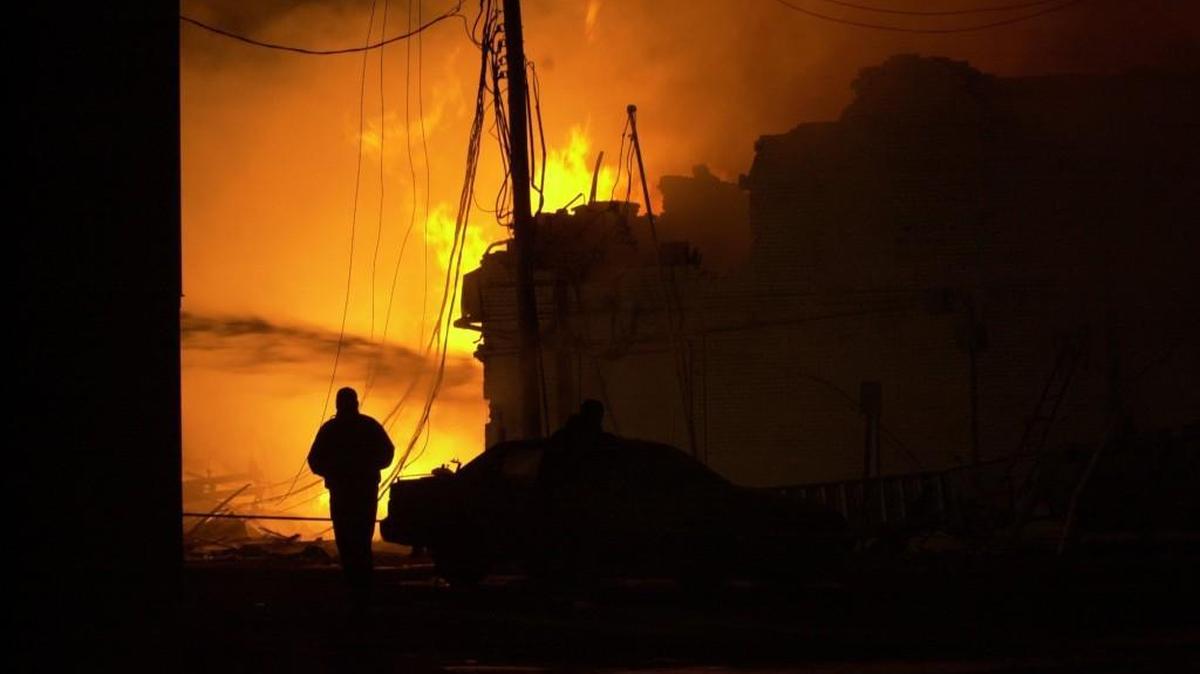 A firefighter walks past a burning fire in downtown Hutchinson, Kan., on Jan. 17, 2001.