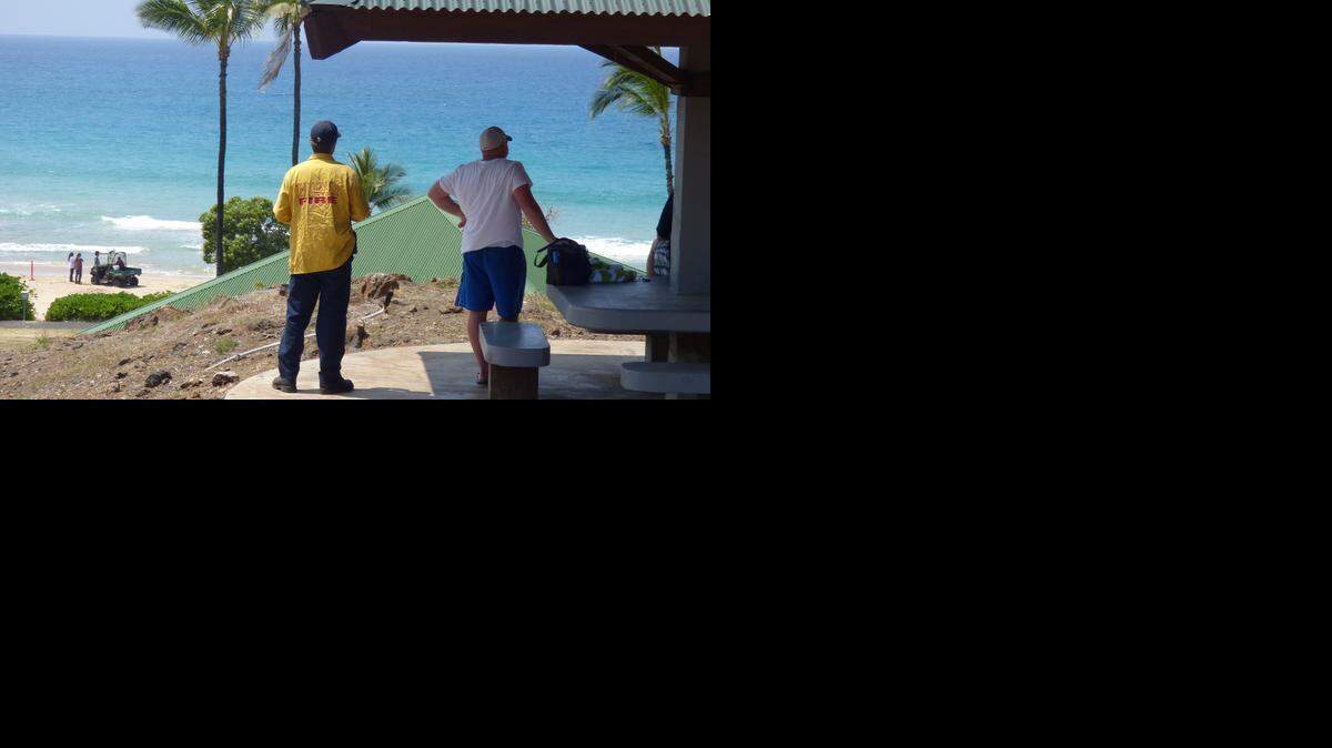 
A Hawaii County Fire Department member scans the shoreline following a shark attack Wednesday in waters off Hapuna Beach State Recreation Area on the Big Island. 
