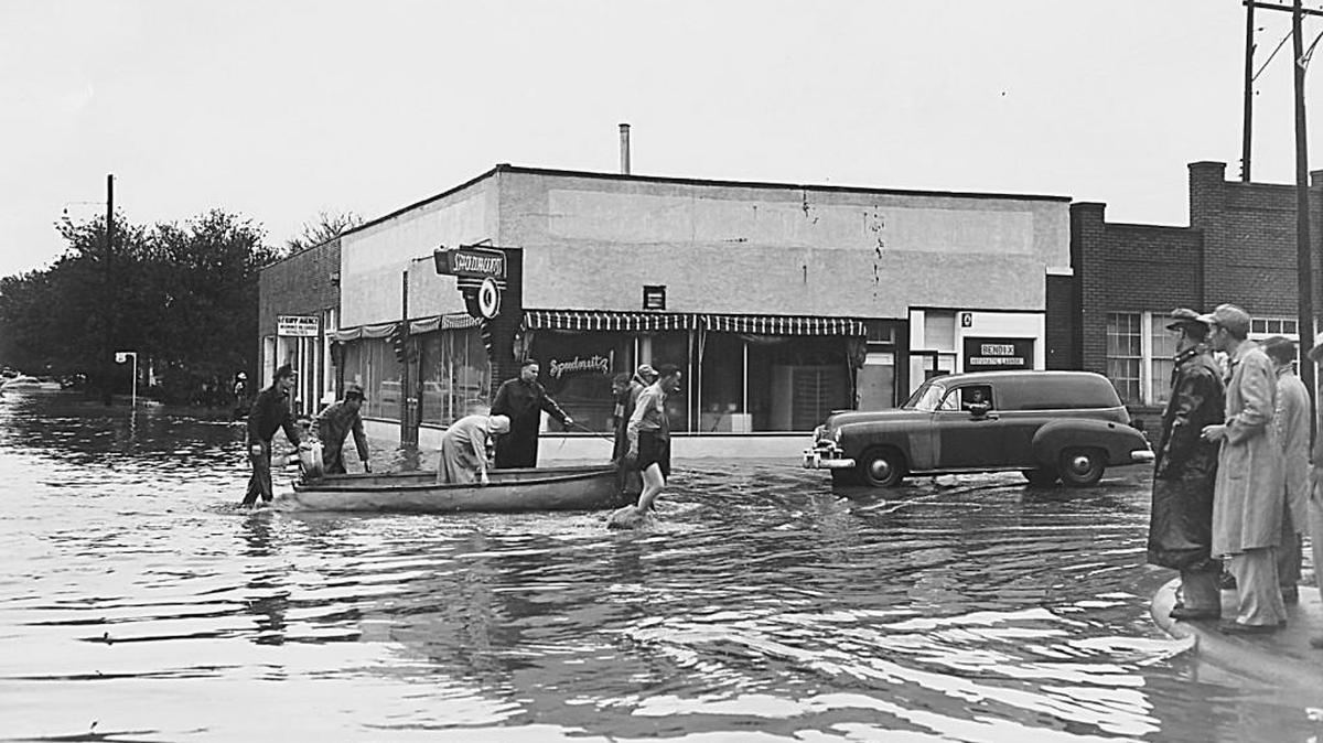 People with boats help residents in Hays after the devastating May 22, 1951, flood, when waters rose in Big Creek, flooding Hays and killing six people.
