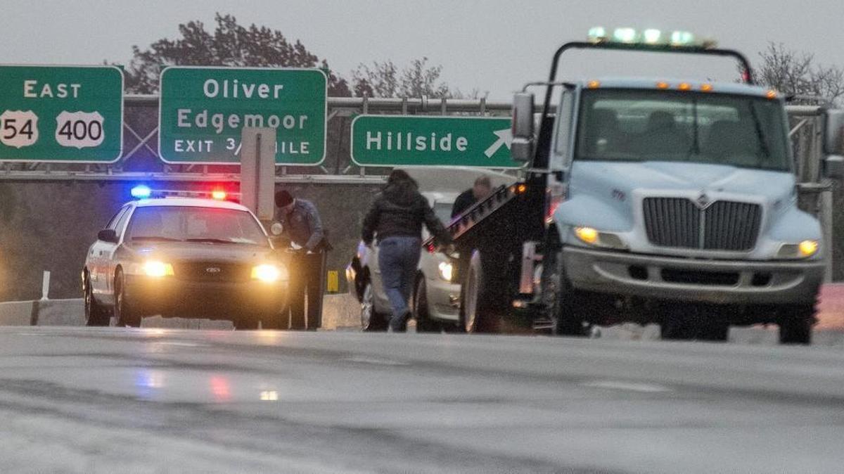 Wichita police protect a tow truck loading one of four cars involved an accident on East Kellogg near Hillside on Friday morning.
