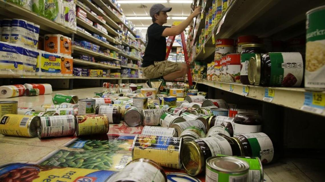 Max Horn helps to clean up the damage in White’s Foodliner after an early morning earthquake in Pawnee, Okla., on Saturday.