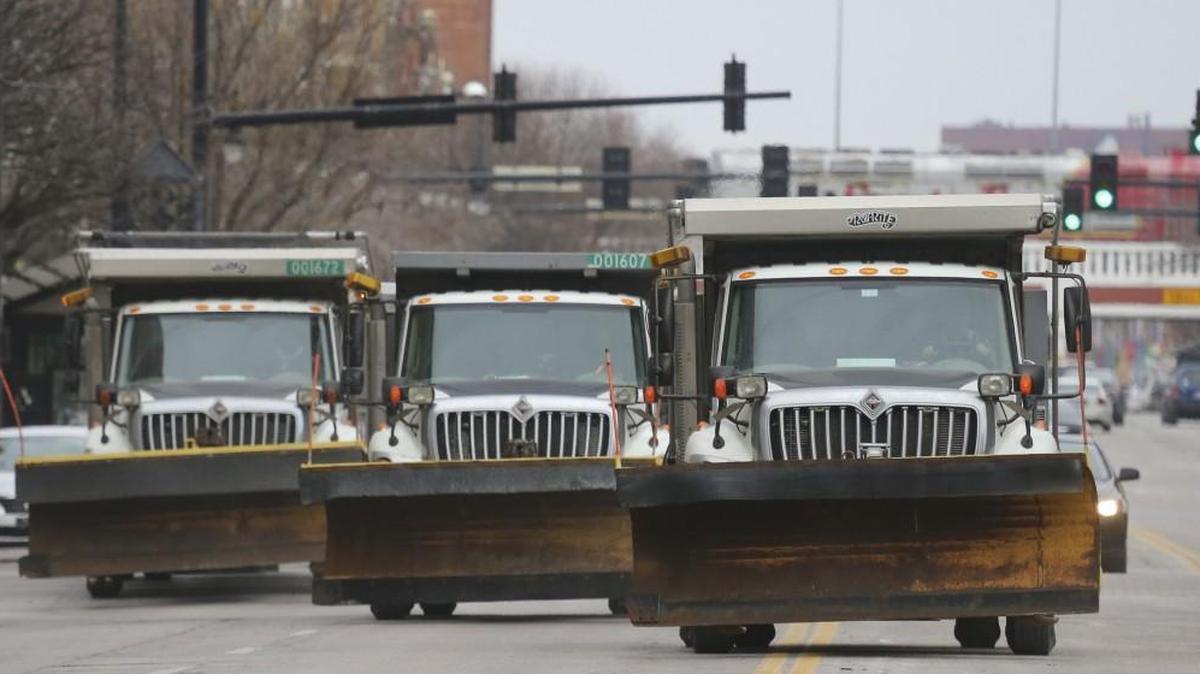 City of Wichita snowplows are lined up three-wide Saturday while spreading a layer of sand on Douglas in preparation for the second round of an ice storm expected to hit the area.