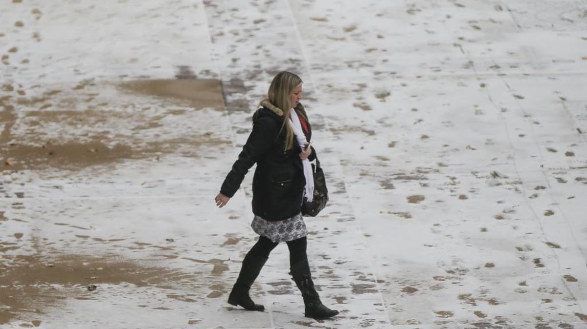 A pedestrian walks across a snow-covered sidewalk on Broadway. Wichita could see snow flurries early Saturday.