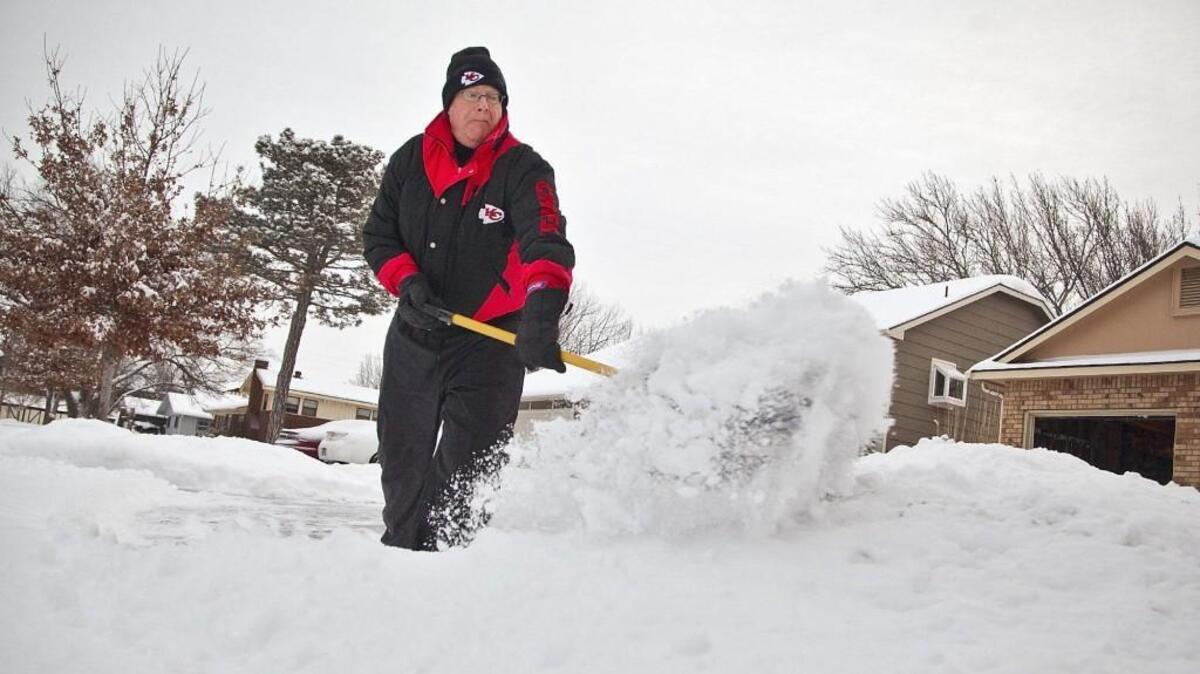 Steve Berg shovels more than 4 inches of fresh snow from his driveway in 2014.