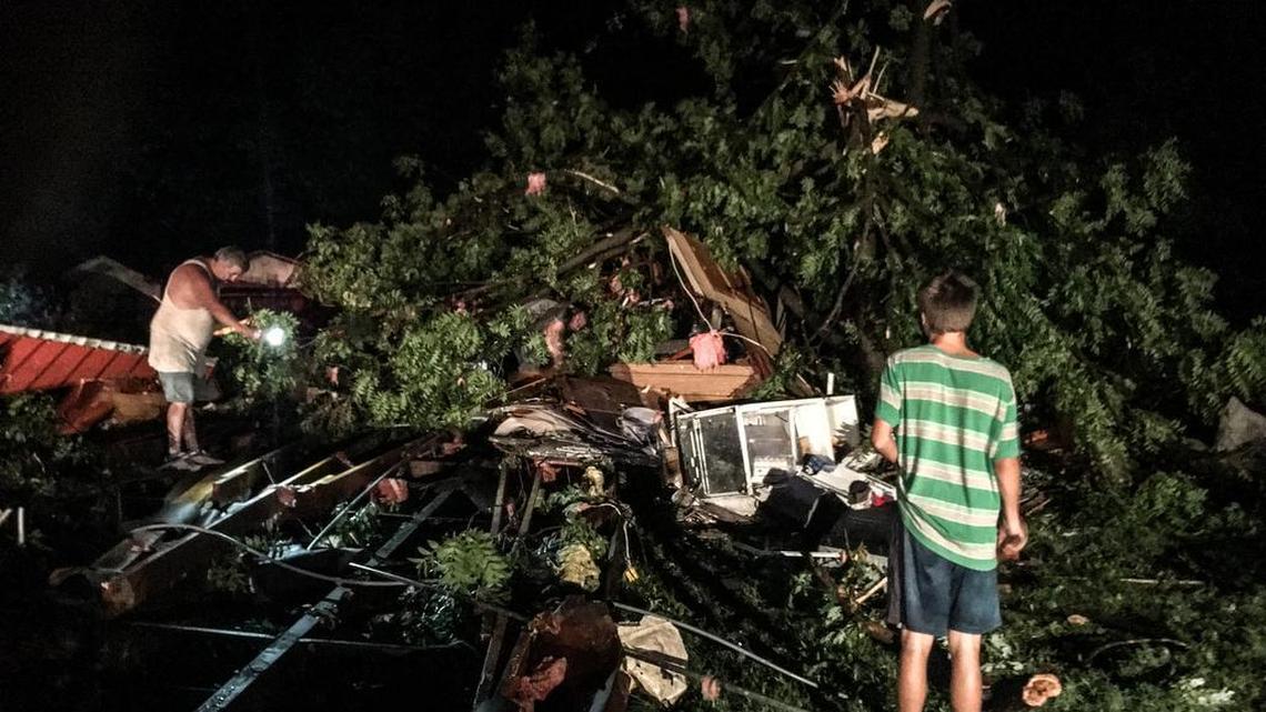 Levi Brown looks at the damage done to his family’s three mobile homes in Eureka, Kansas, by a tornado Thursday night, as the father of one of his family’s tenants surveys the destruction.