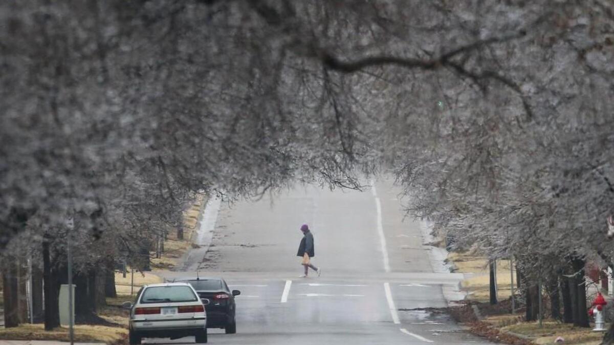 A pedestrian walks north on Hillside among a canopy of ice-covered trees on Sunday morning. The Wichita area saw a slight accumulation of ice overnight, but not enough to knock out power or cause much damage.