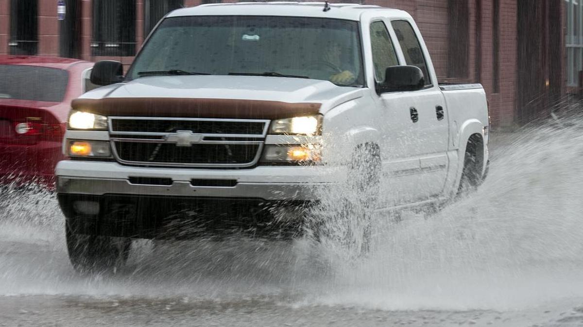 A driver navigates a flooded Mosley Street in Old Town during a brief downpour early Thursday afternoon. (May 26, 2016)