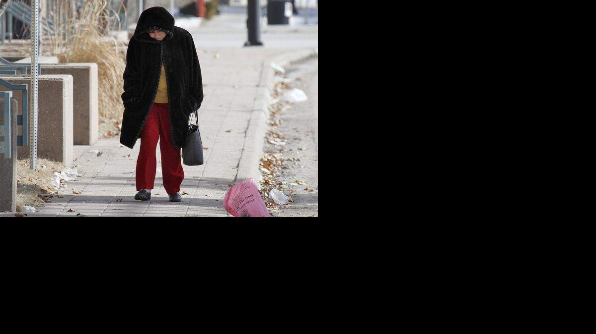 
Cora Diehl walks to her job Wednesday at the State Office building downtown. Wichita woke up shivering Wednesday, with blowing snow, harsh north winds and wind chills several degrees below zero. (Jan. 7, 2015)
