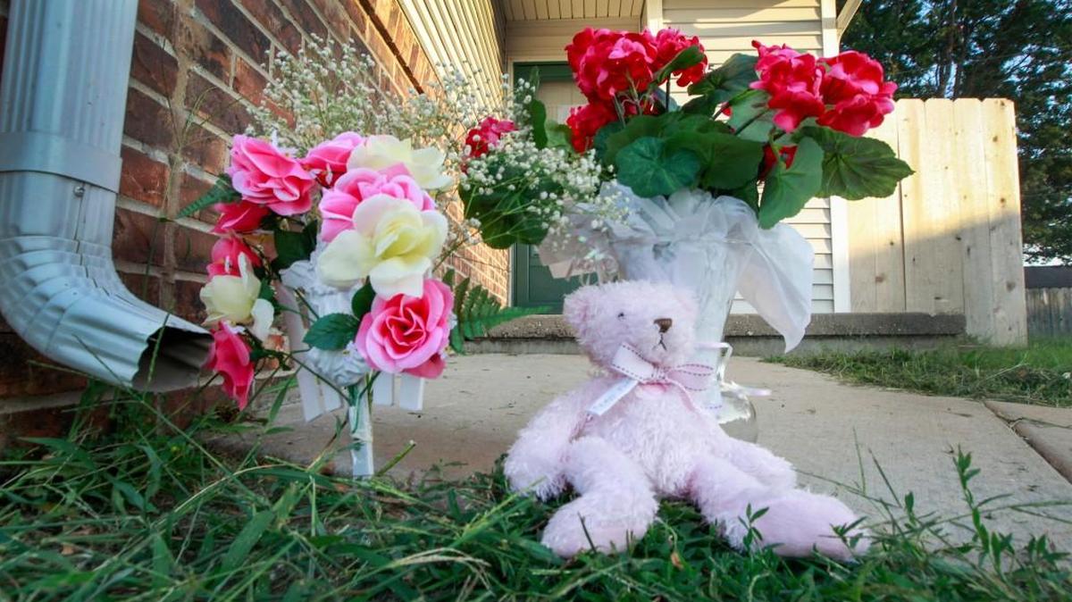 Flowers and a teddy bear sit outside the home of Alyssa Runyon and her 4-year-old daughter Zaylynn Paz on Aug. 11. The couple were found dead at their home Aug. 8.