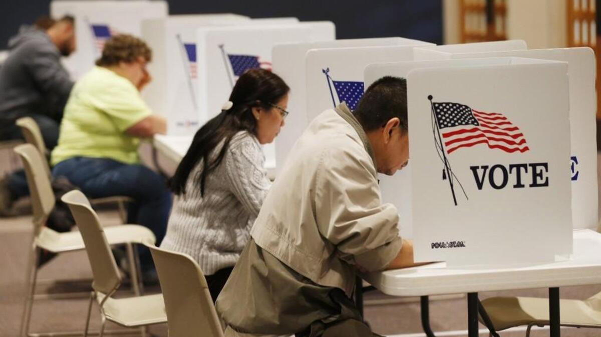 Voters fill out paper ballots at First Mennonite Brethren church on west 21st street early Tuesday morning.  Voters had choice of paper ballots or machine voting. (November 8, 2016)