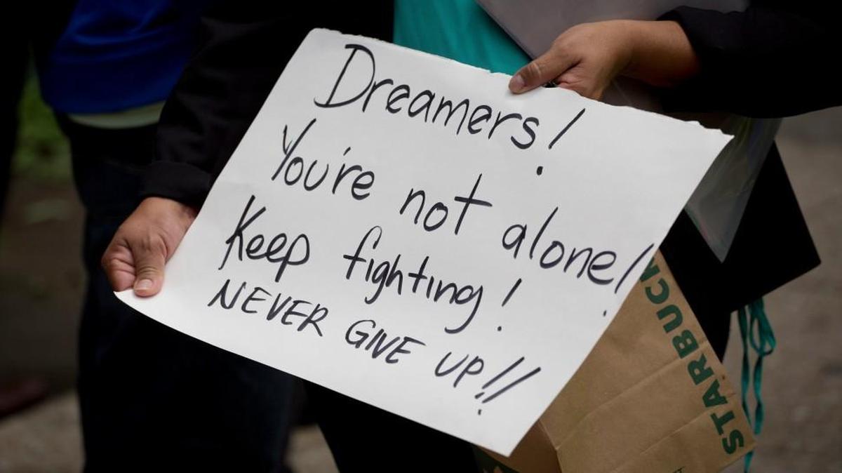 A woman holds up a handwritten message as people protest in support of the Deferred Action for Childhood Arrivals outside U.S. embassy in Mexico City on Tuesday.