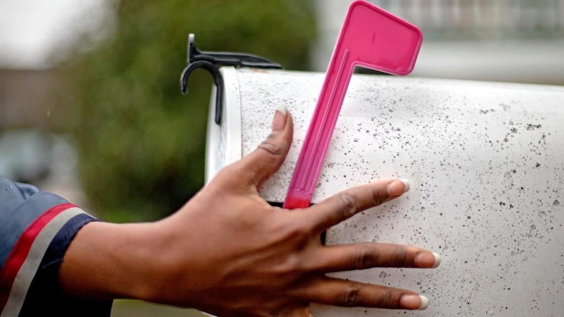 U.S. Postal Service letter carrier of 12 years, Jamesa Euler, turns down the flag on a mailbox while delivering mail in the Cabbagetown neighborhood, Thursday, Feb. 7, 2013, in Atlanta. The financially struggling U.S. Postal Service wants to stop delivering mail on Saturdays but continue to deliver packages six days a week under a plan aimed at saving about $2 billion a year. (AP Photo/David Goldman)