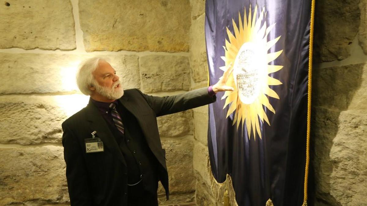 State architect Barry Gries looks at the original Kansas banner from 1923, on display at the visitors center in the Kansas Statehouse in 2014.