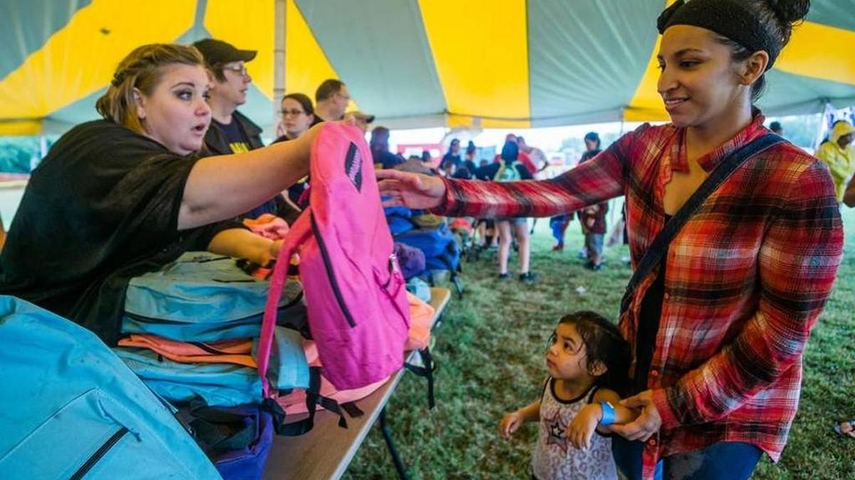 Silian Rodriguez and her daughter receive a free backpack during the Convoy of Hope event Saturday morning at the Bethel Life Center.