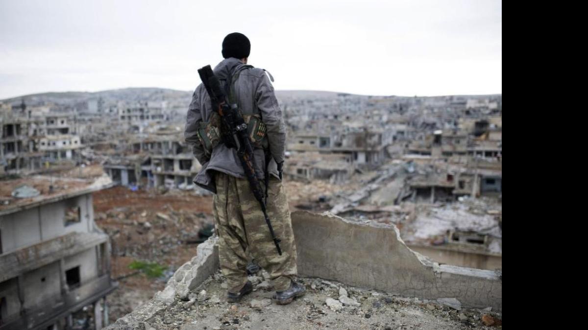 
A Syrian Kurdish sniper looks at the rubble in the Syrian city of Ain al-Arab.
