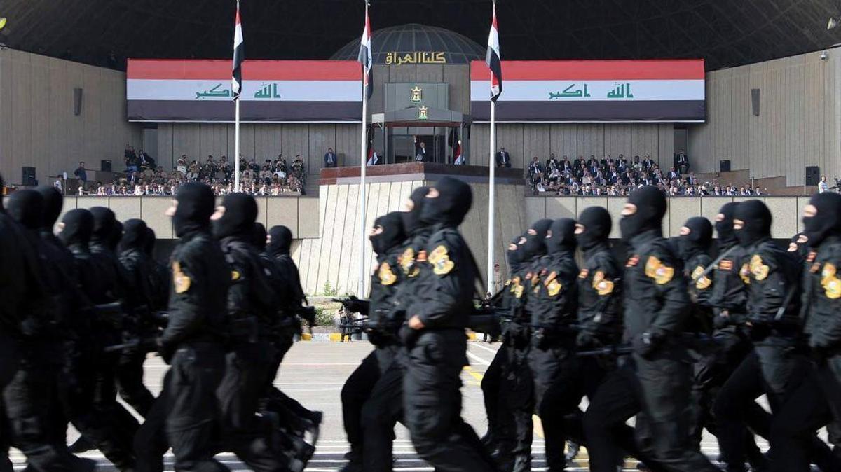 Iraqi troops march in a military parade in Baghdad on Saturday in front of Prime Minister Haider al-Abadi, background center, during victory celebrations over Islamic State militants.