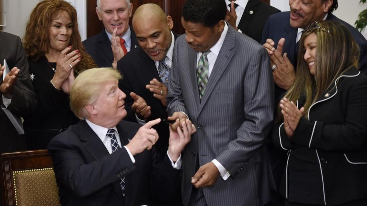 President Donald Trump gives the pen to Isaac Newton Farris, Dr. Martin Luther King’s nephew, after signing a proclamation to honor King on Friday at the White House.