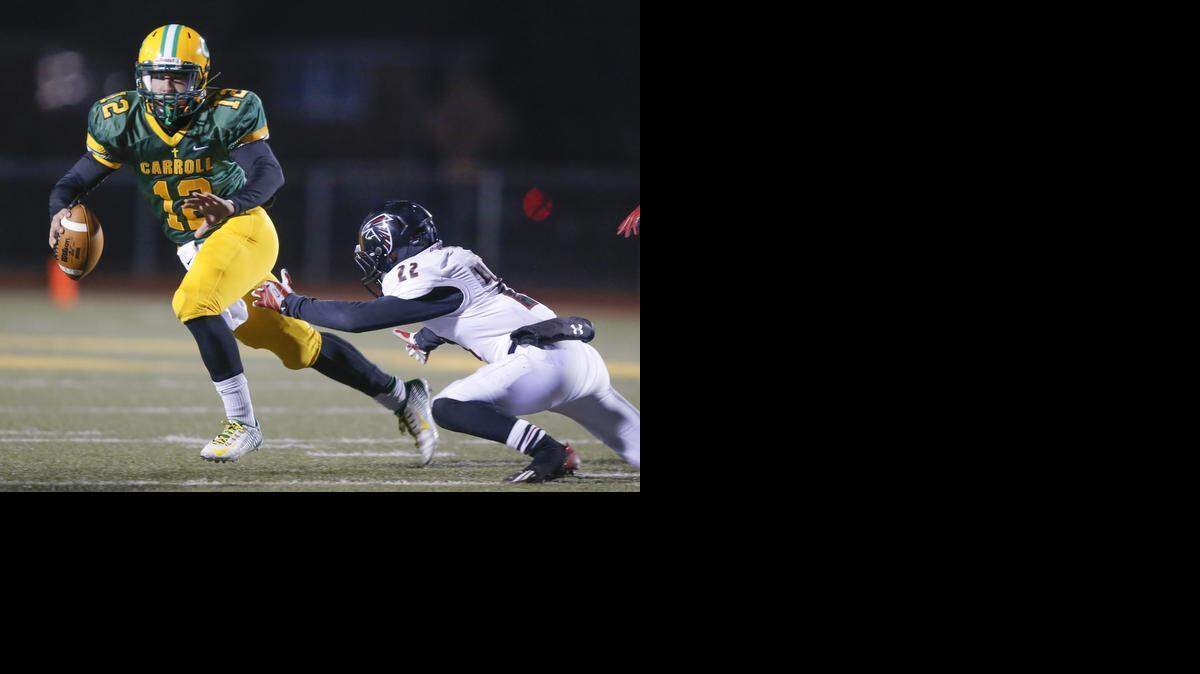 
Bishop Carroll quarterback Colton Howell scrambles away from Heights' defender Garrison Freeman during the first half on Friday night. 
