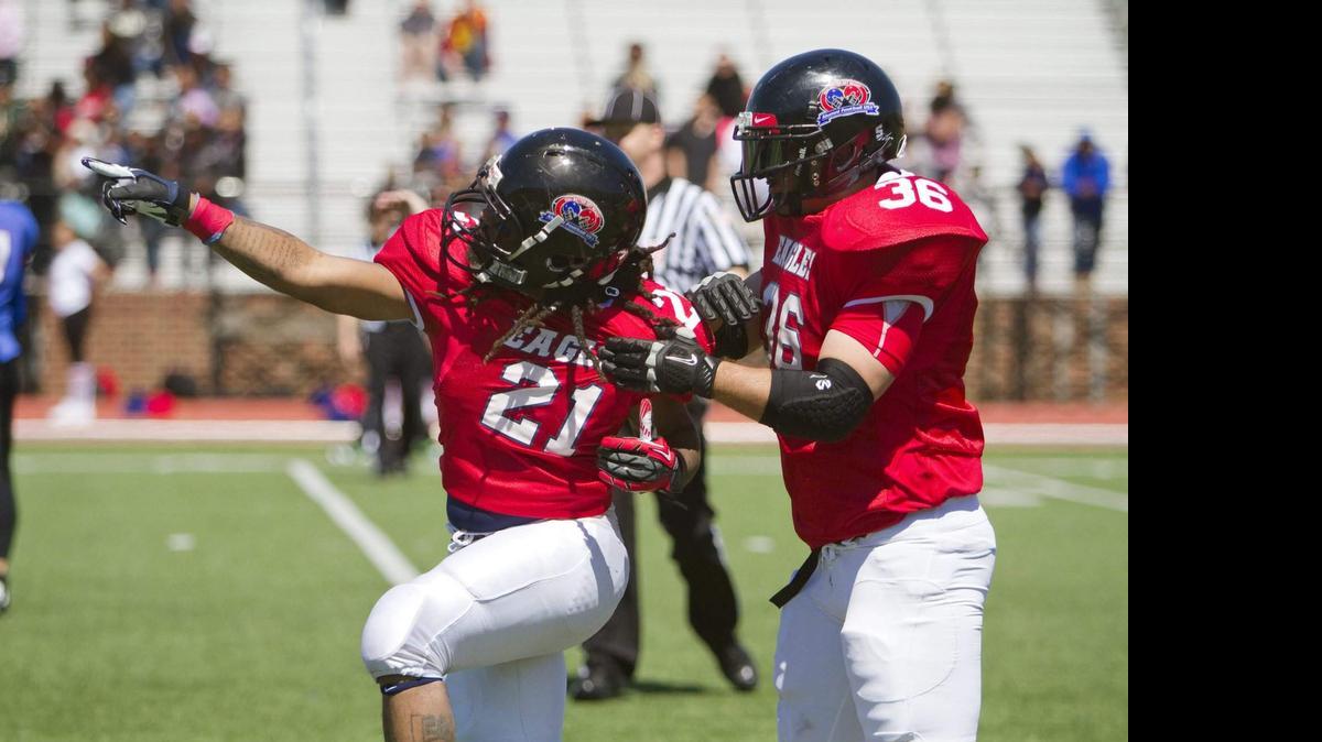 
Edinson High alumni football players celebrate during an Alumni Football USA game against T.C. Williams High in Alexandria, Va. T.C. Williams was the high school portrayed in the 2000 film “Remember the Titans” starring Denzel Washington. 

