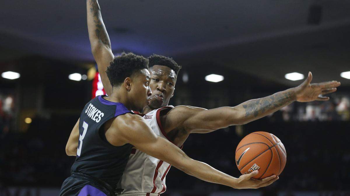 Kansas State guard Kamau Stokes scoops a shot under the arm of Oklahoma forward Kristian Doolittle during the first half of Wednesday’s game in Norman, Okla.