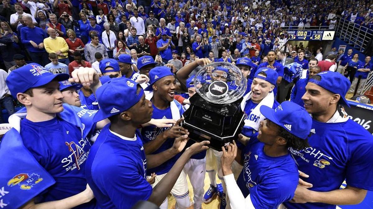 Kansas players celebrate a 12th consecutive Big 12 Conference title with a 67-58 win against Texas Tech on Saturday.