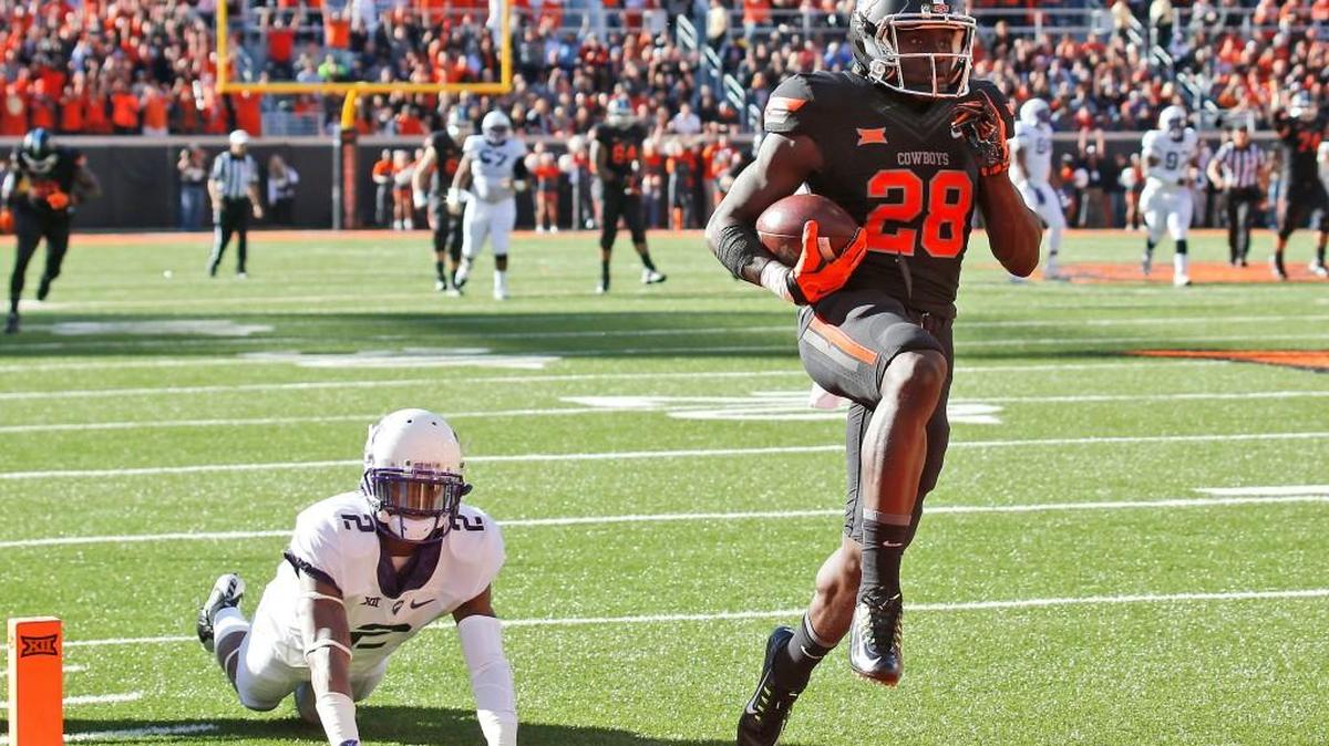 Oklahoma State wide receiver James Washington carries a Mason Rudolph pass into the end zone for a touchdown in front of TCU cornerback Torrance Mosley.