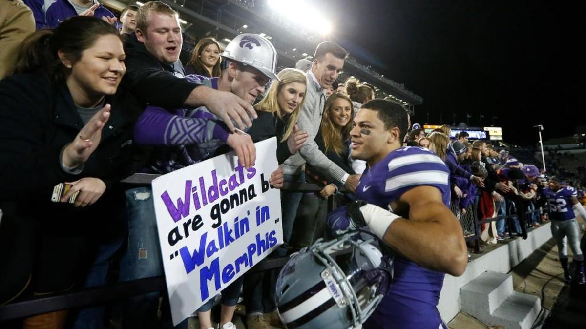 Kansas State defensive back Morgan Burns celebrates with fans as the Wildcats celebrated defeating West Virginia 24-23 Saturday in Manhattan. Burns had a 97 yard game winning kick off return. (December 5, 2015)