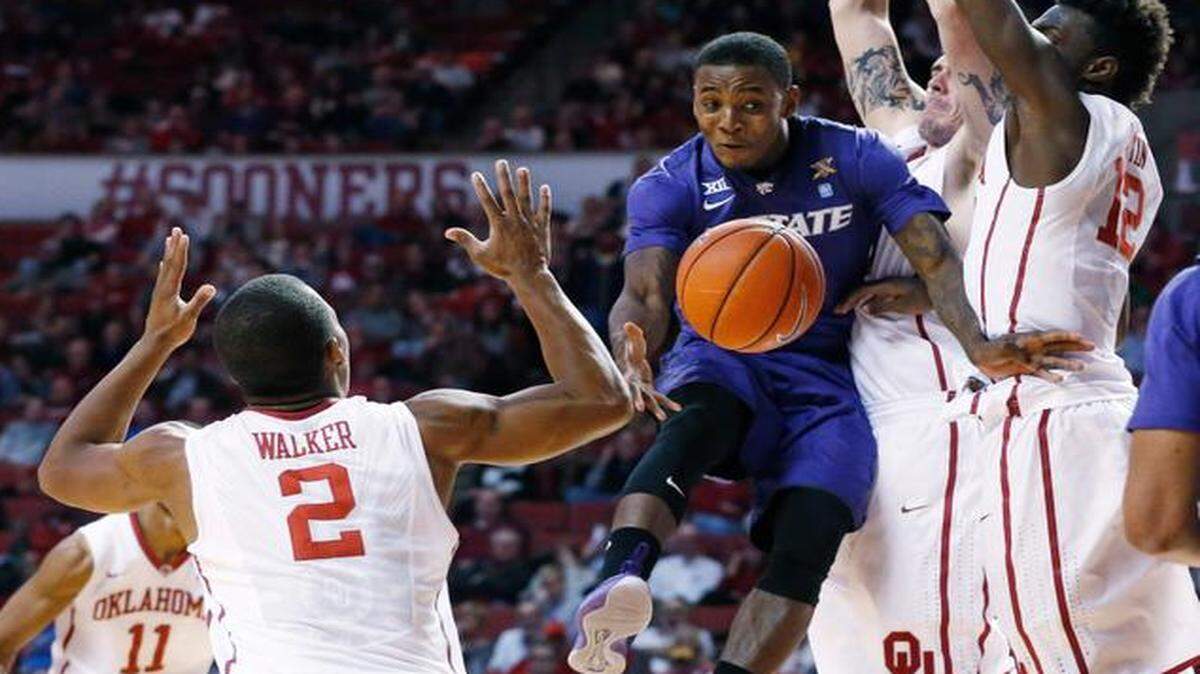 
Kansas State guard Jevon Thomas drives between Oklahoma’s Dinjiyl Walker (2), Ryan Spangler and Khadeem Lattin, right, in the first half Saturday in Norman, Okla.
