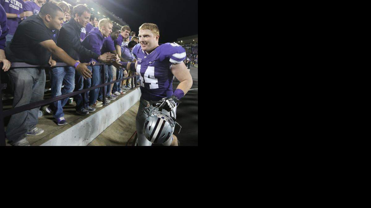 
K-State defensive end Ryan Mueller is congratulated by fans as he circles the stadium Saturday night after the Wildcats defeated Kansas 51-13 in November.
