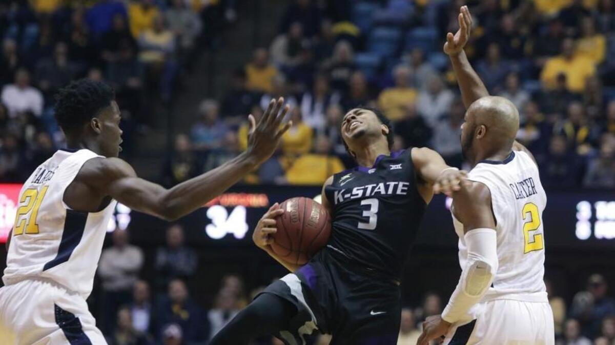 Kansas State guard Kamau Stokes is fouled by West Virginia guard Jevon Carter, right, during the first half Saturday in Morgantown, W.Va.