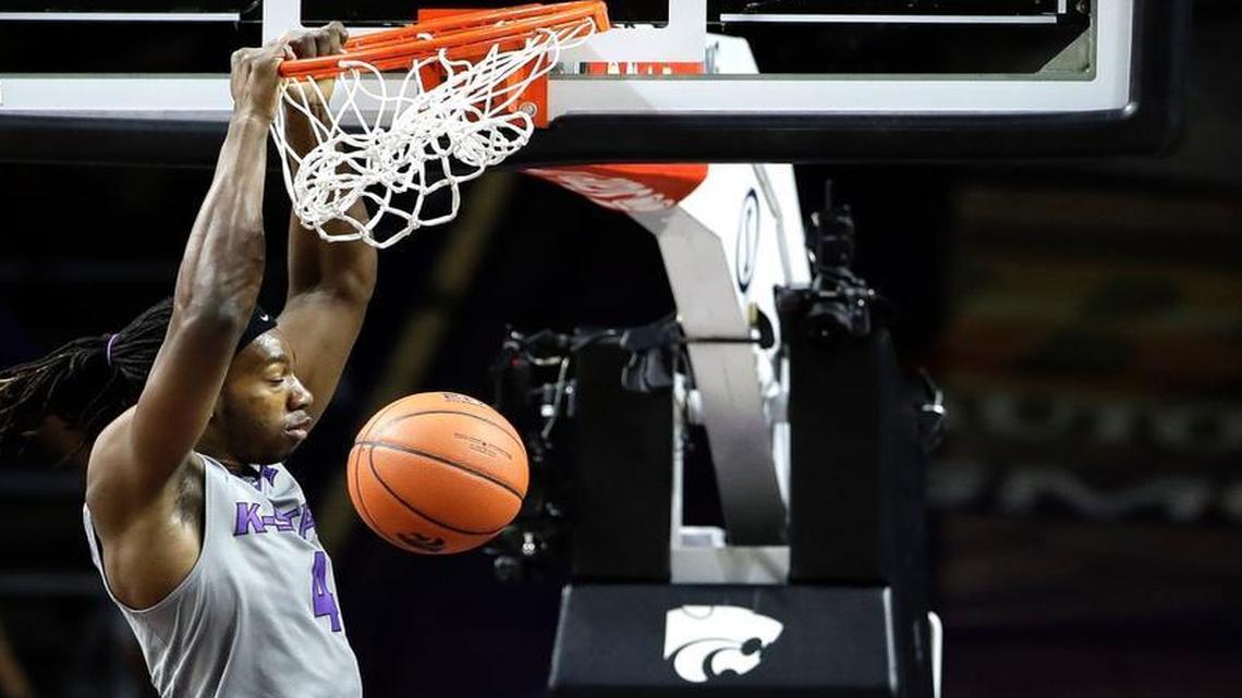 Kansas State’s D.J. Johnson gets past Texas’ Kerwin Roach to dunk the ball during the first half Friday night in Manhattan.